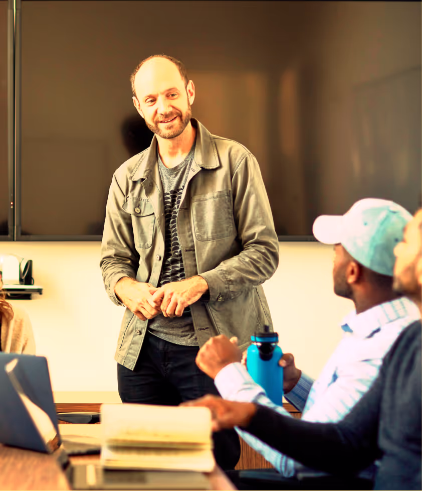 A team lead reviewing plans with teammates in a meeting